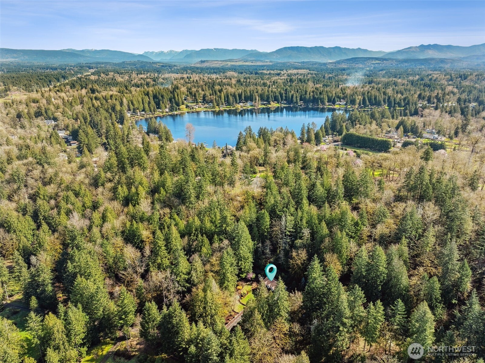 A bird’s-eye view showcases the property’s expansive grounds, with the lake visible in the distance.