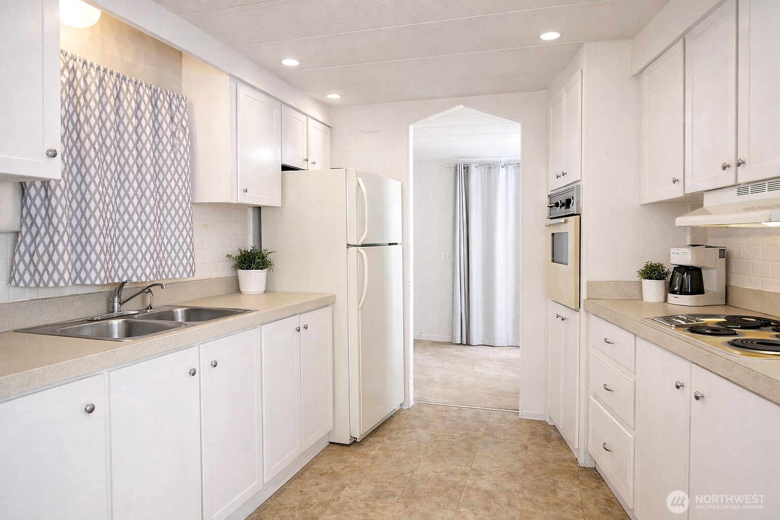 The kitchen opens up toward the dining area, with the second refrigerator clearly visible in this view. Brand new garbage disposal.(view from the laundry area.) VIRTUALLY STAGED