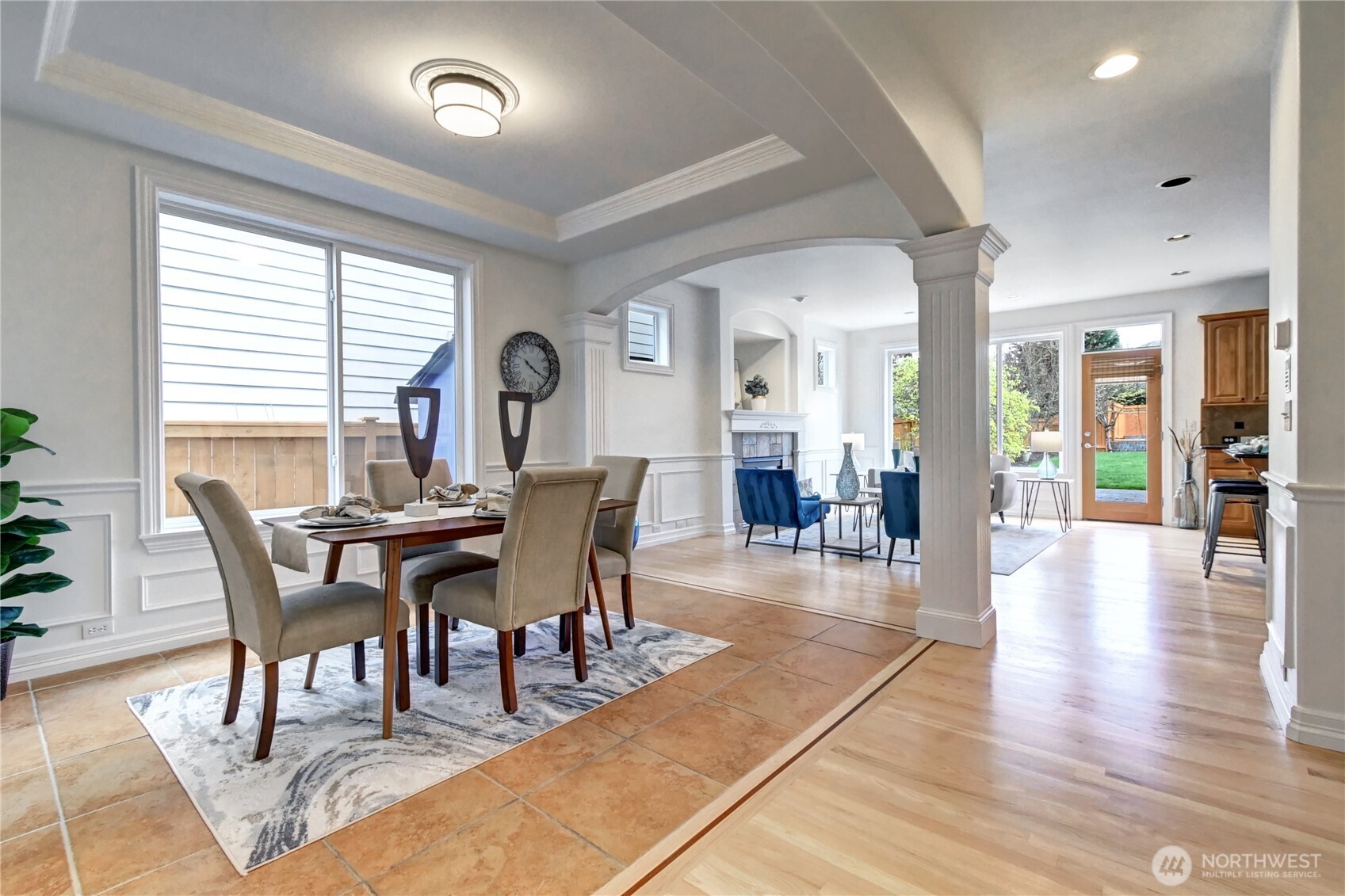 Dining room with pillars, arches, custom millwork & tile flooring.