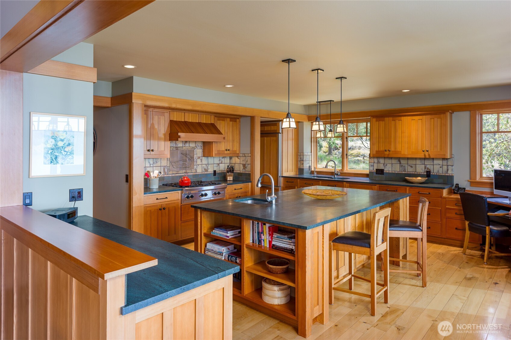 Chef's kitchen with spacious slate counters, madrona floors, fir cabinets, double sinks and built-in desk.