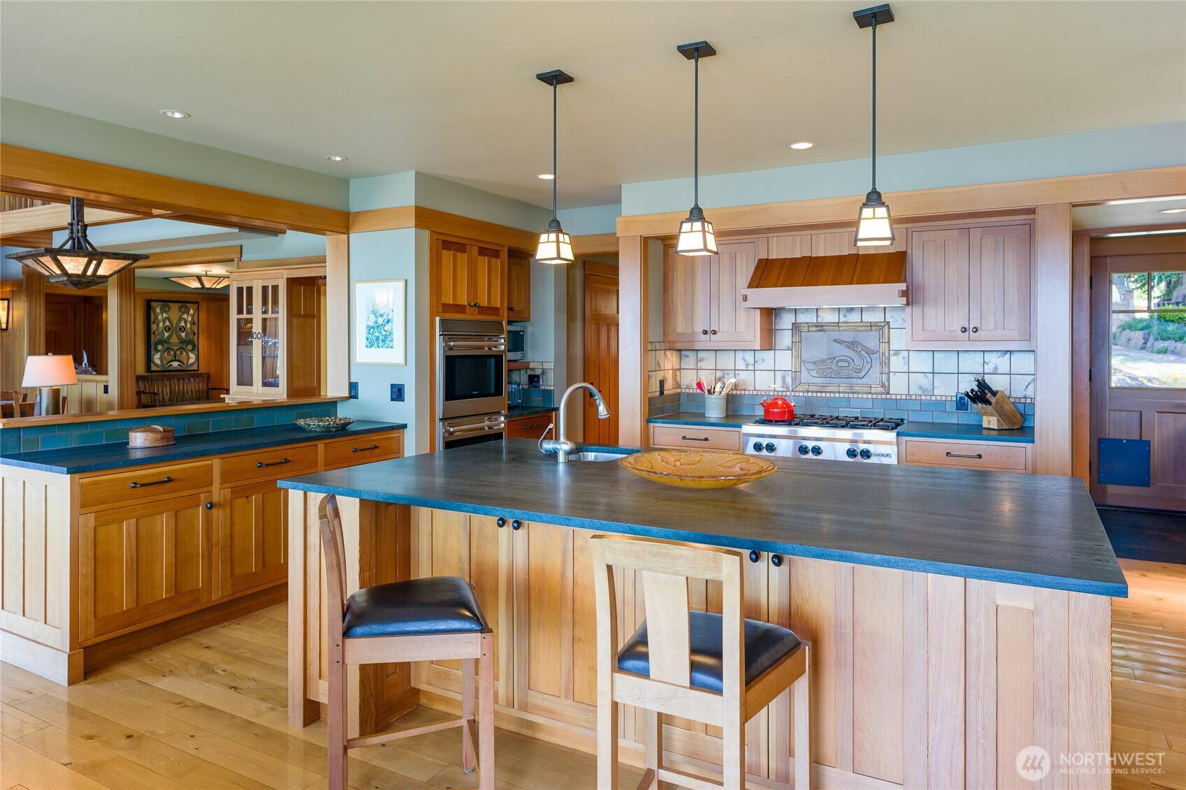 Clear fir cabinets, double ovens and Wolf cooktop.  Back door is right back.
