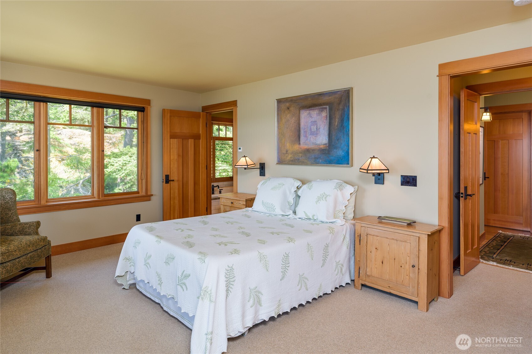 Another view of the main floor primary bedroom.  Ensuite bathroom door in middle of picture.