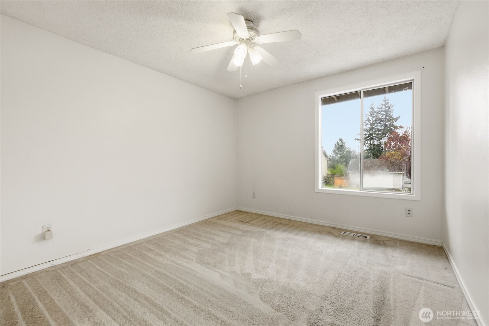 Lower-level Bedroom 5 featuring natural light and views of the backyard.