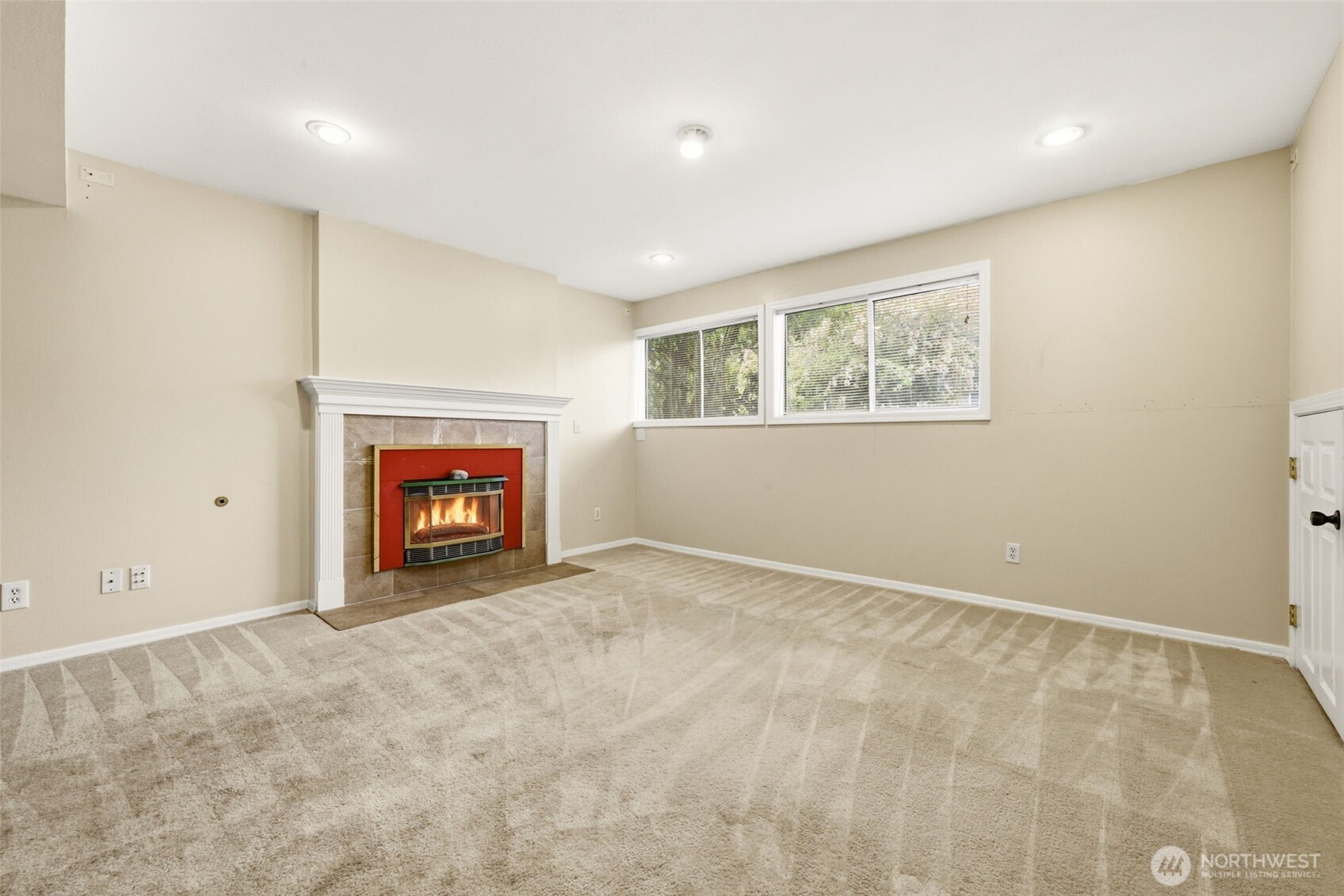Lower-level bonus room with natural gas fireplace, offering flexible living or recreation space.