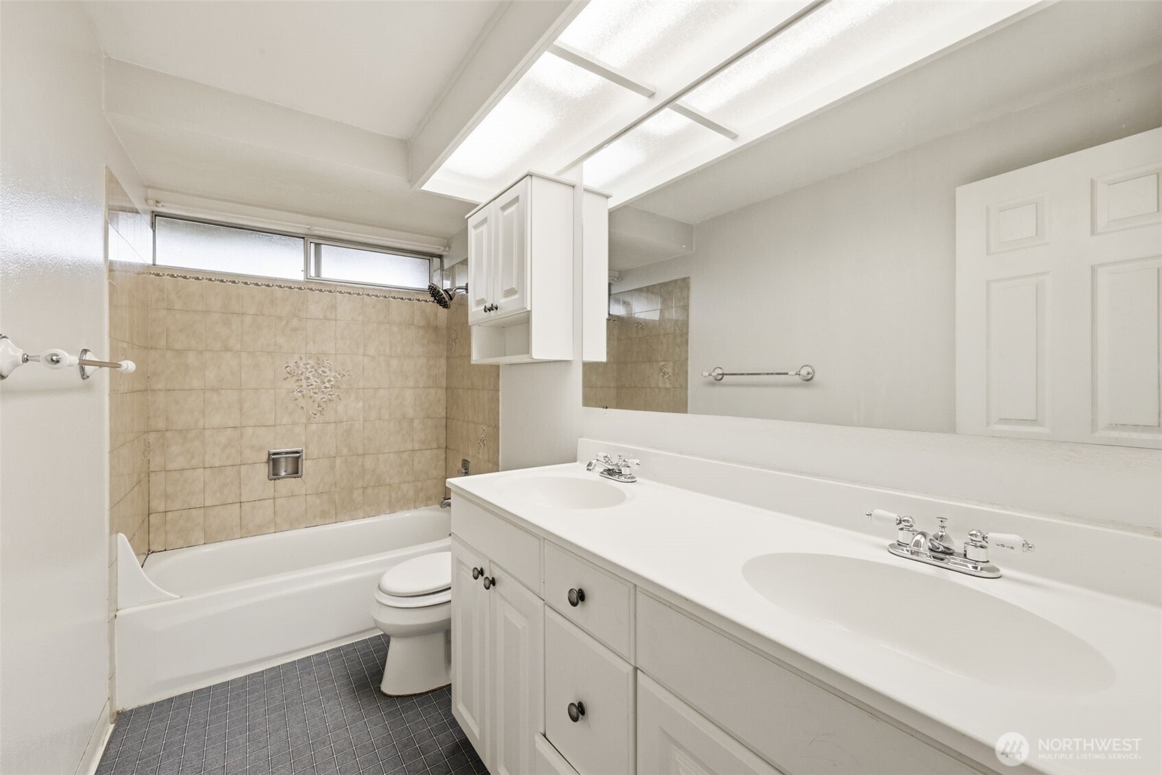 Main bathroom with double vanity and full tub/shower—ideal for shared use.