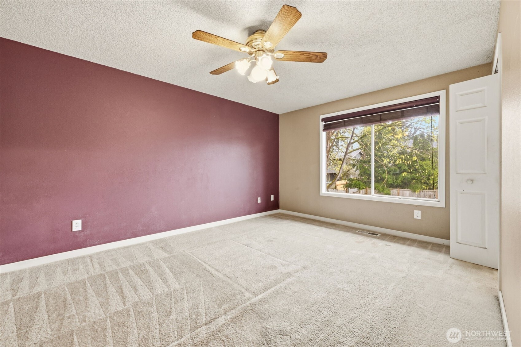 Well-sized primary bedroom with ensuite bath and walk-in closet, offering views of the backyard.