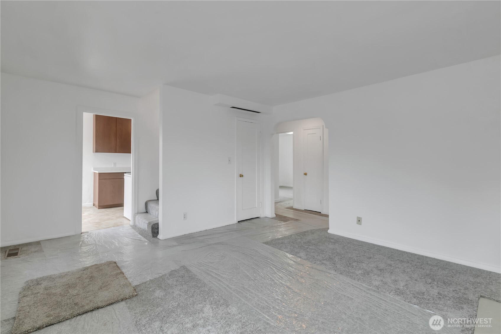 Living room with access to stairs and kitchen.