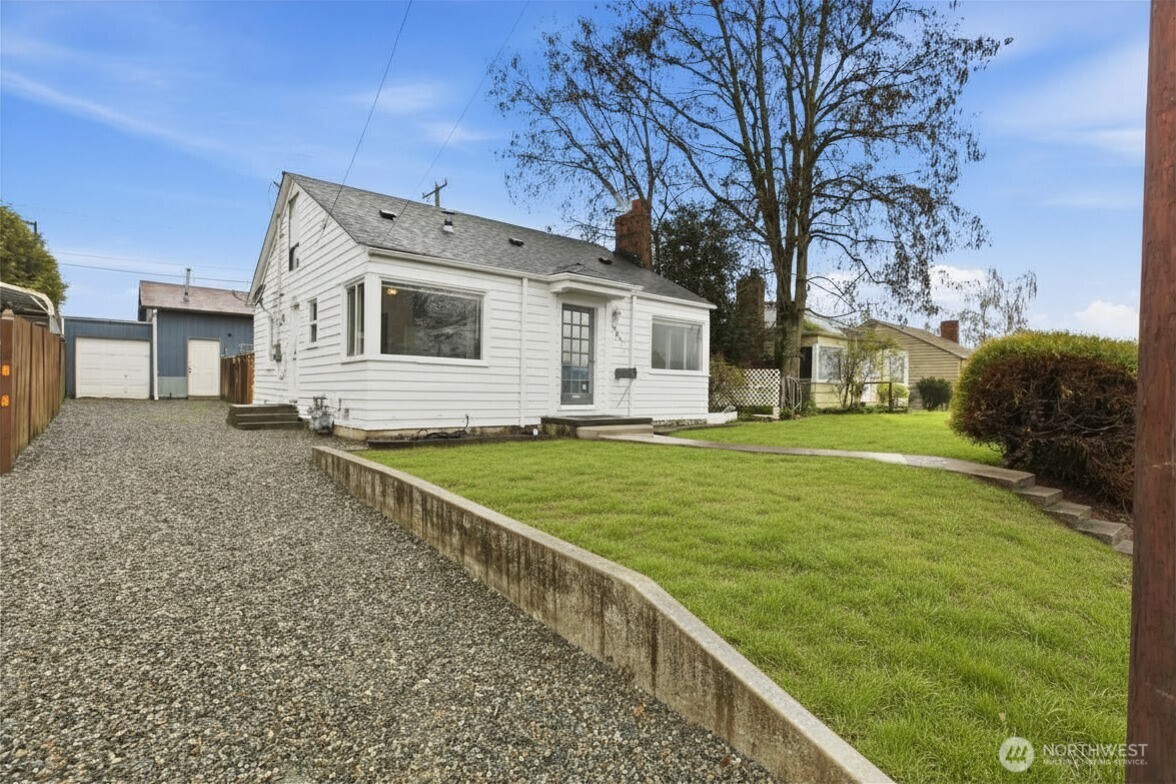 Front of home with gravel driveway and extra off-street parking. (Grass is virtual- seed is currently in the dirt)