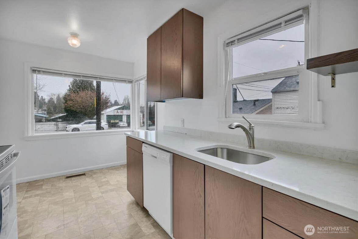 Newly remodeled eat-in kitchen with new stove and dishwasher.
