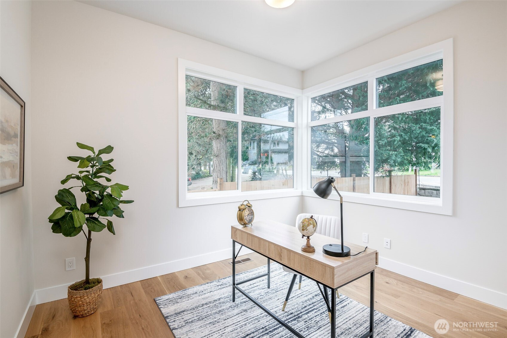 Elegant dining space with designer lighting and wide-plank hardwoods, seamlessly connected to bright, open-concept living areas for effortless entertaining.