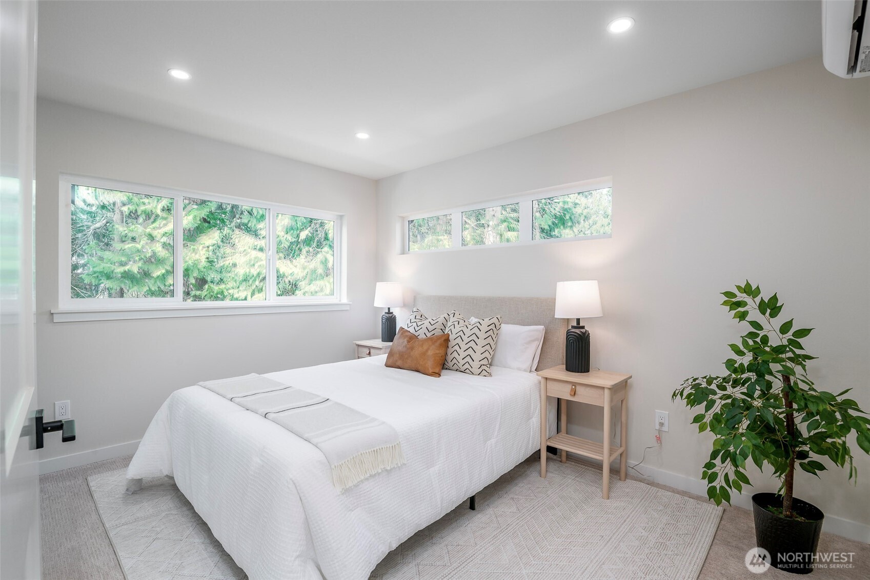 Primary bathroom with walk-in shower, windows positioned for privacy and natural light, accompanied by touches of modern finishes and lighting.