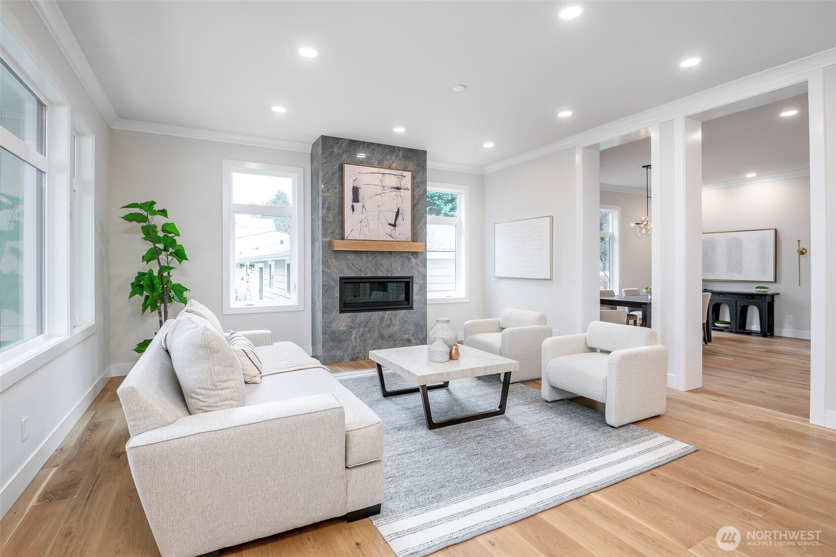 Spacious open-concept great room featuring a chef's kitchen with large island, designer lighting, and seamless flow into inviting living and dining areas.