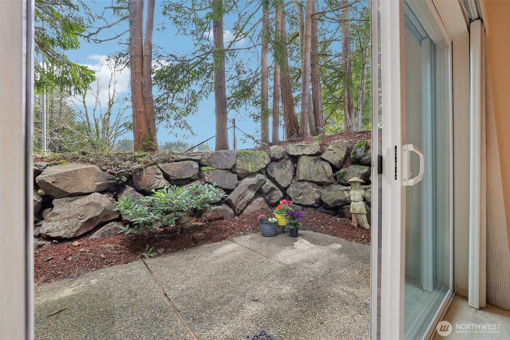 Side Patio with retaining wall creates a personal space to enjoy the spring & summer shade