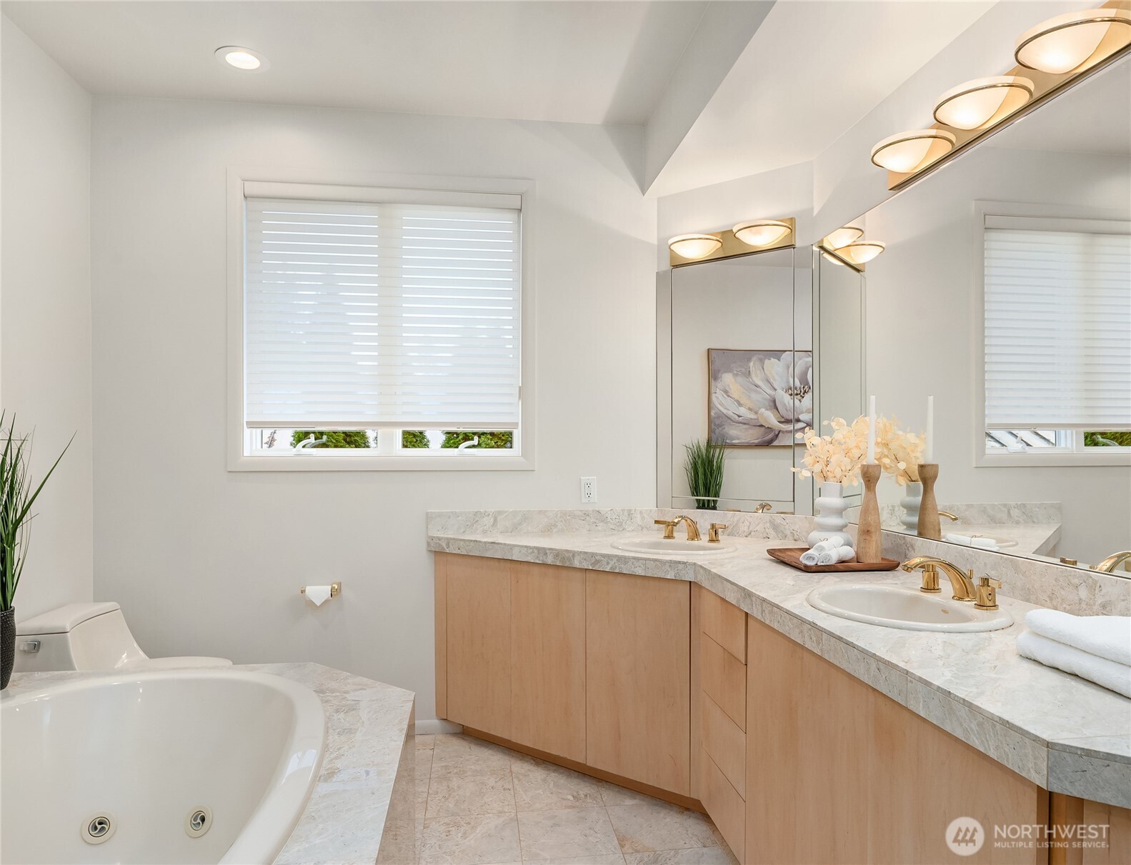 Primary bathroom with jetted tub, dual vanities, and large walk-in shower.