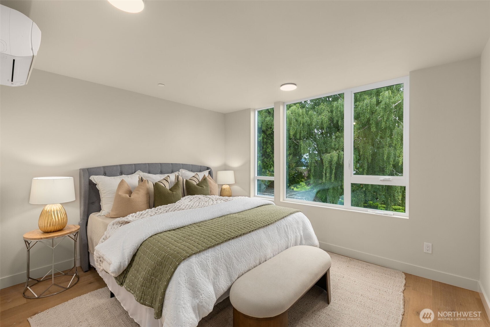 This inviting bedroom is framed by windows and natural textures, creating a peaceful vibe day and night.