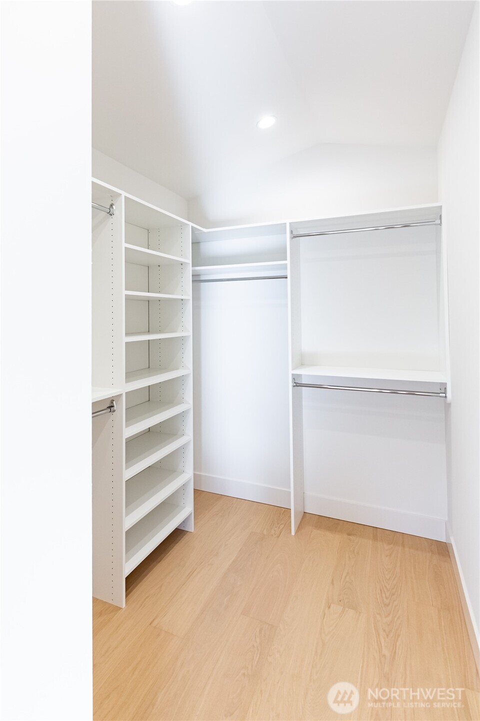 Primary bedroom walk in closet with closet system installed