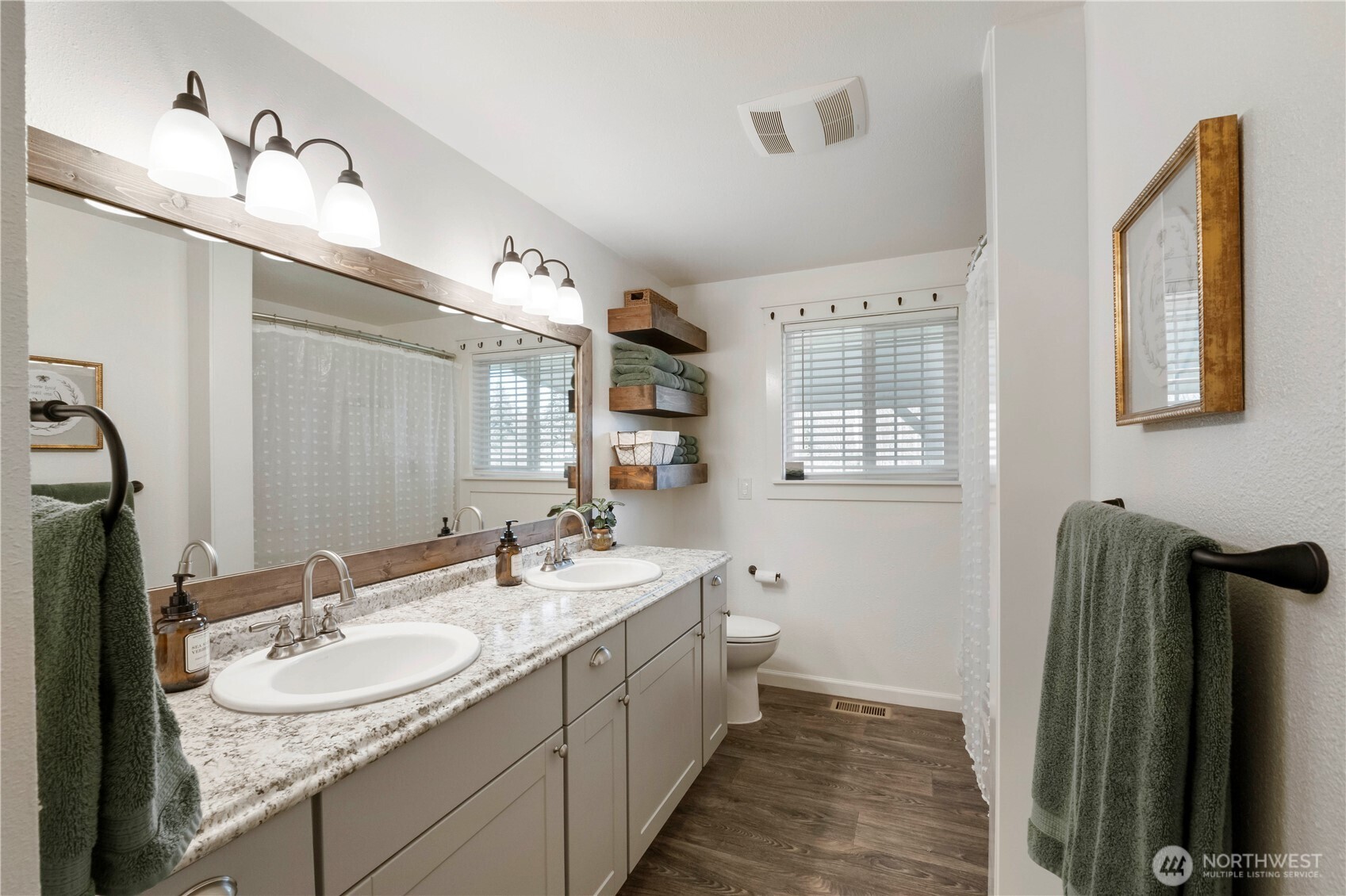 Large, bright main bathroom with double sinks, lots of countertop space with shower/ tub combo