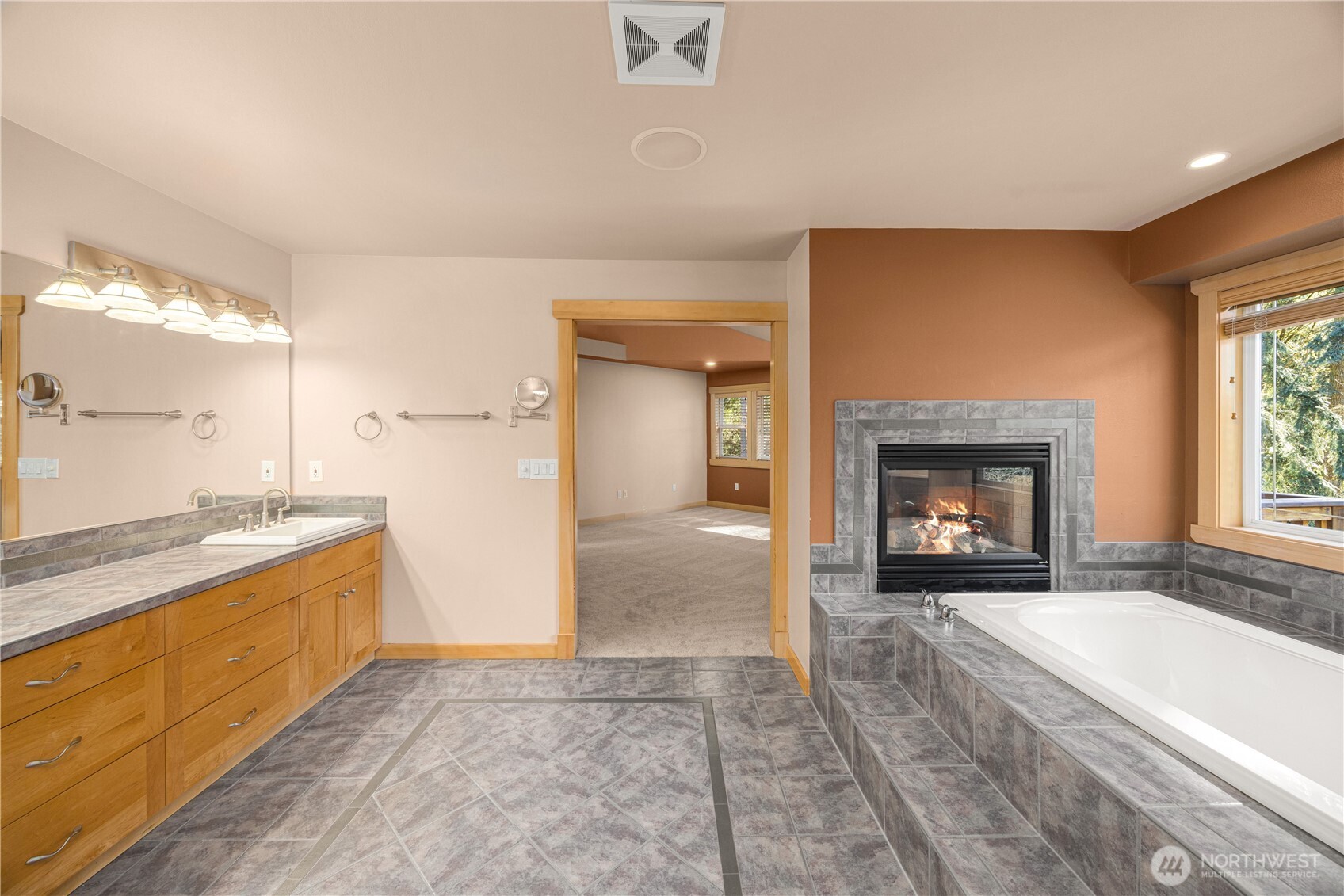 Primary bathroom features: double sided gas fireplace, amazing  soaking tub, heated floors,double vanity sink, and dual shower heads with bench seat.