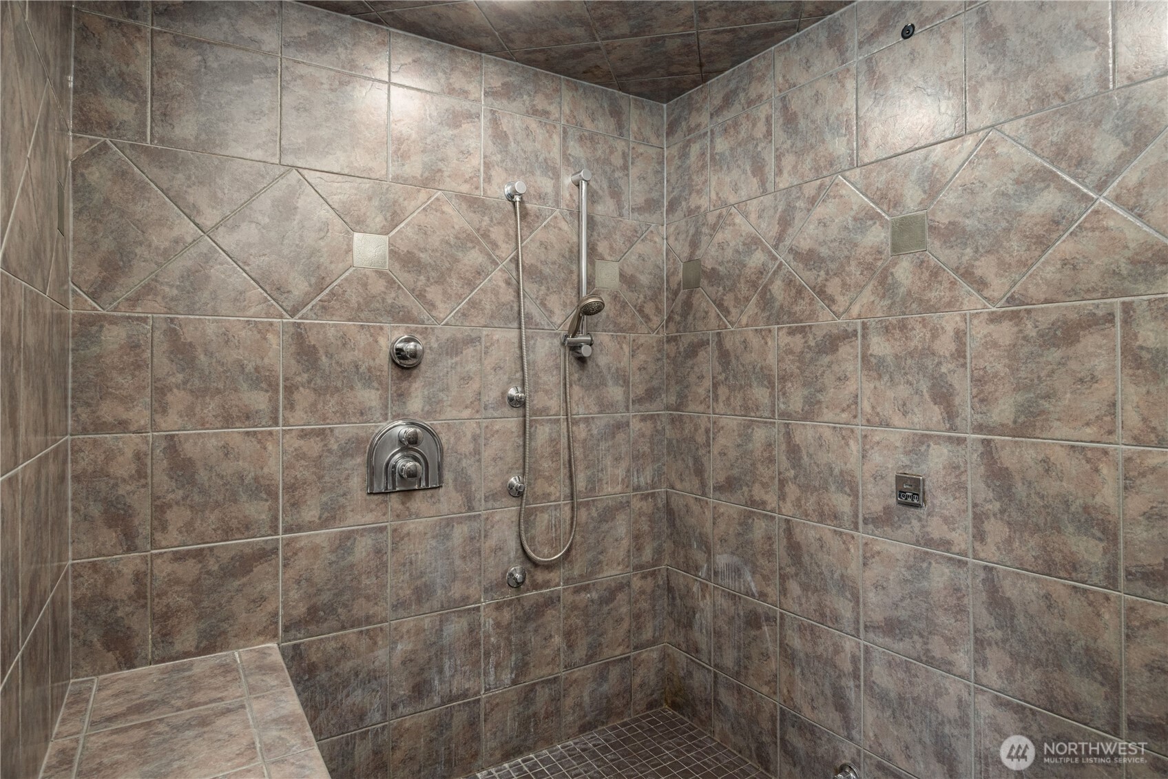 Primary shower with large bench seat & dual shower heads (there is another one on opposite side)