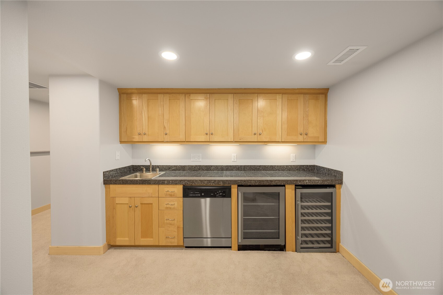 Kitchenette with wine cooler and mini fridge on lower level