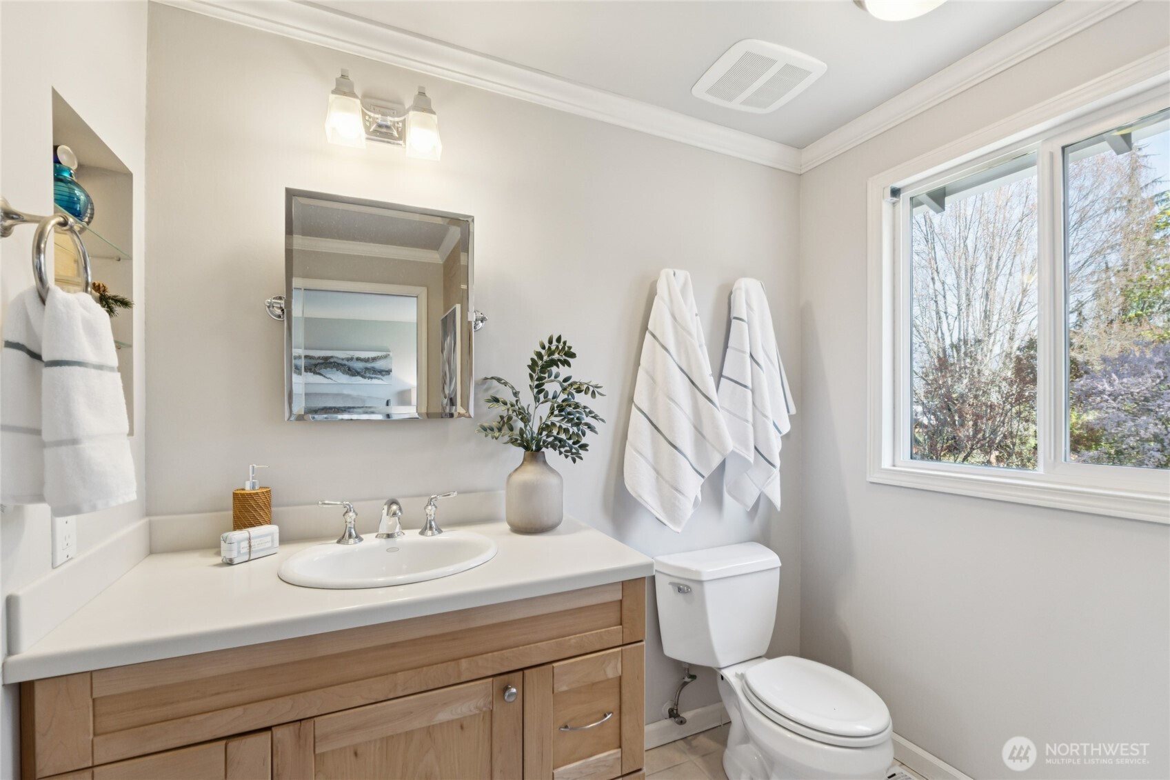 Clean, updated finishes and a window to the outdoors give the bathroom a refined, practical feel.