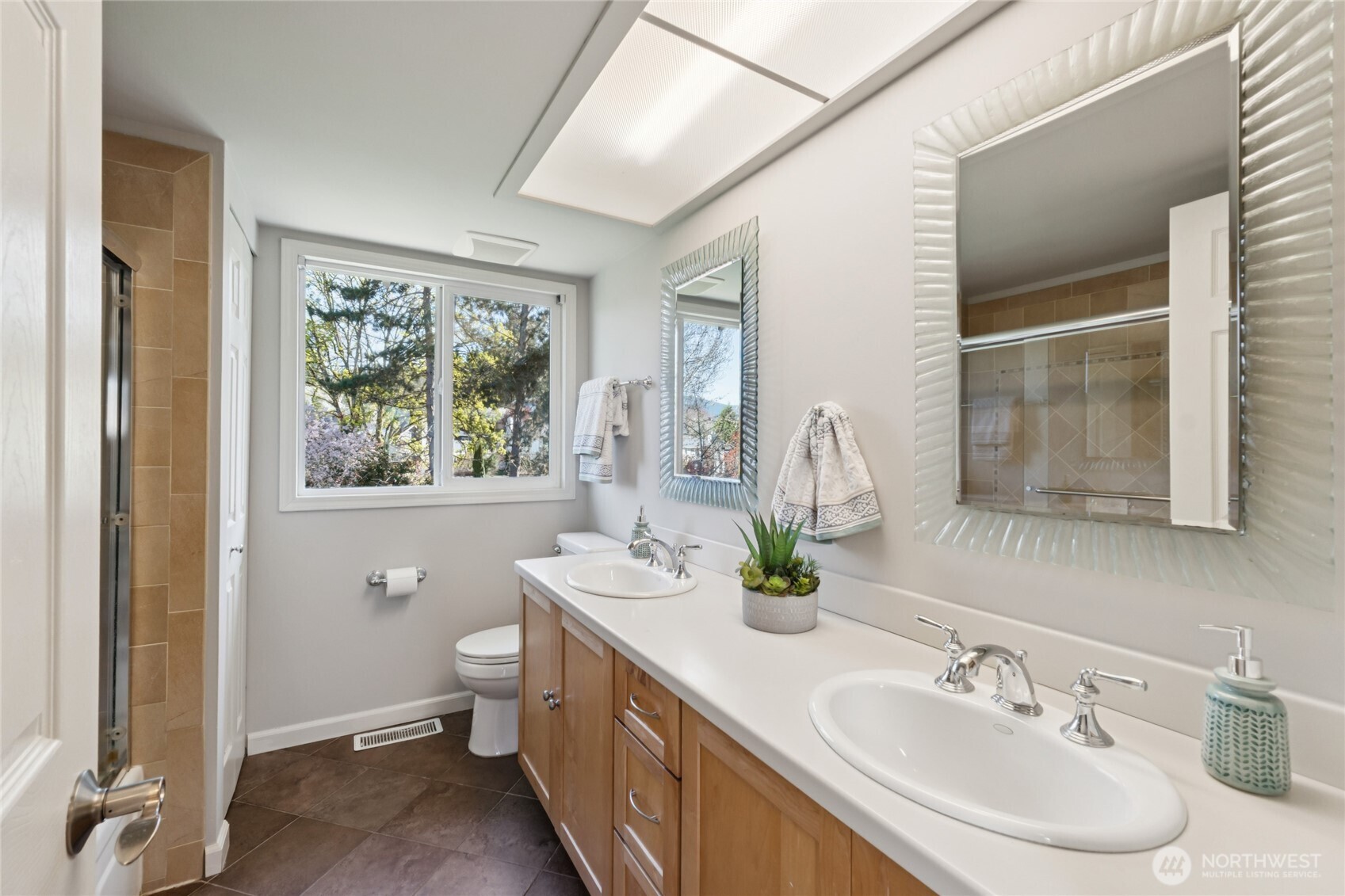 A full bath with dual sinks, tiled flooring, and a tub—well laid out and functional!