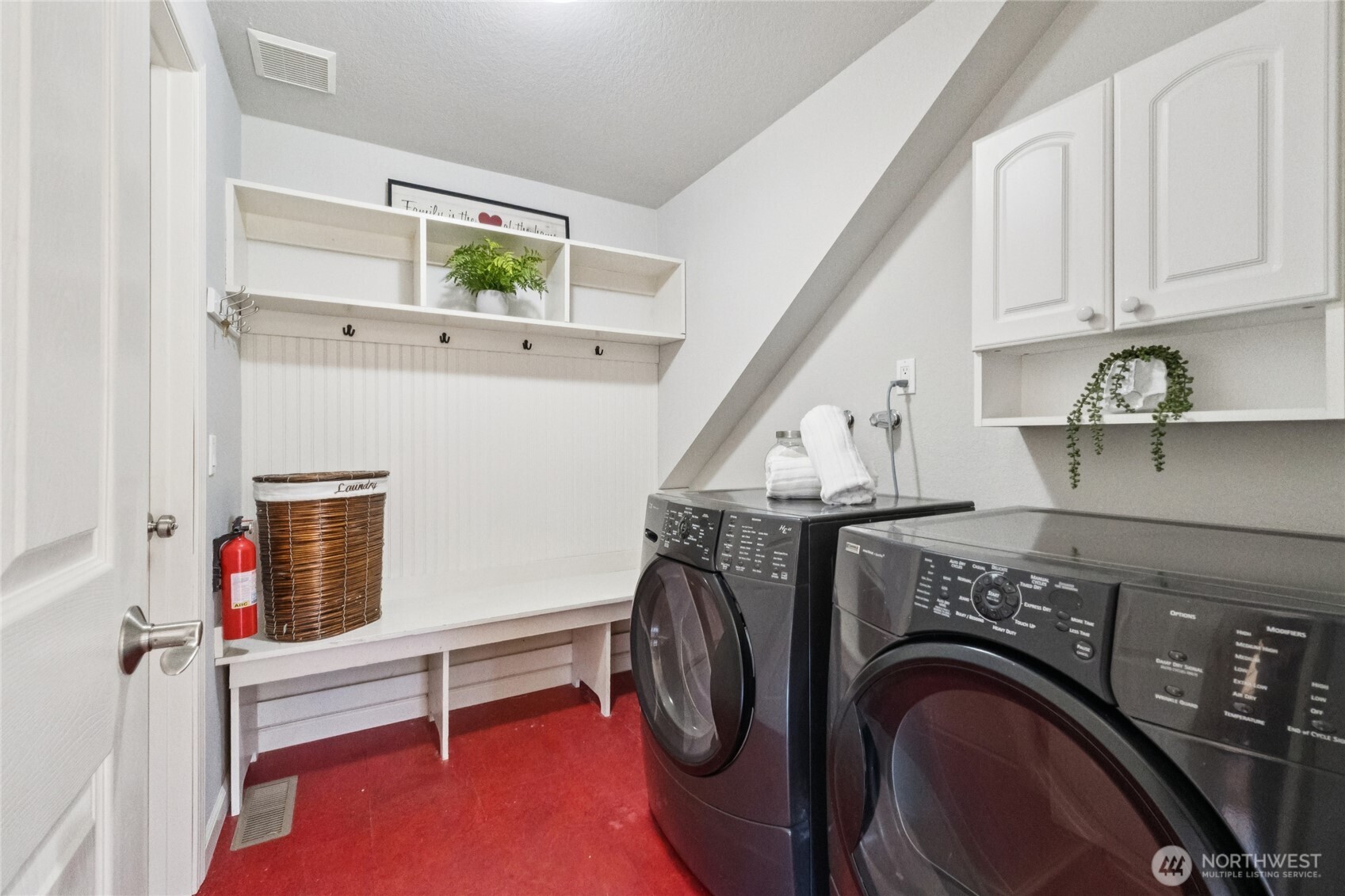 A dedicated mudroom and laundry space with built-in bench seating and hooks—designed for organization, with direct access to the oversized garage.
