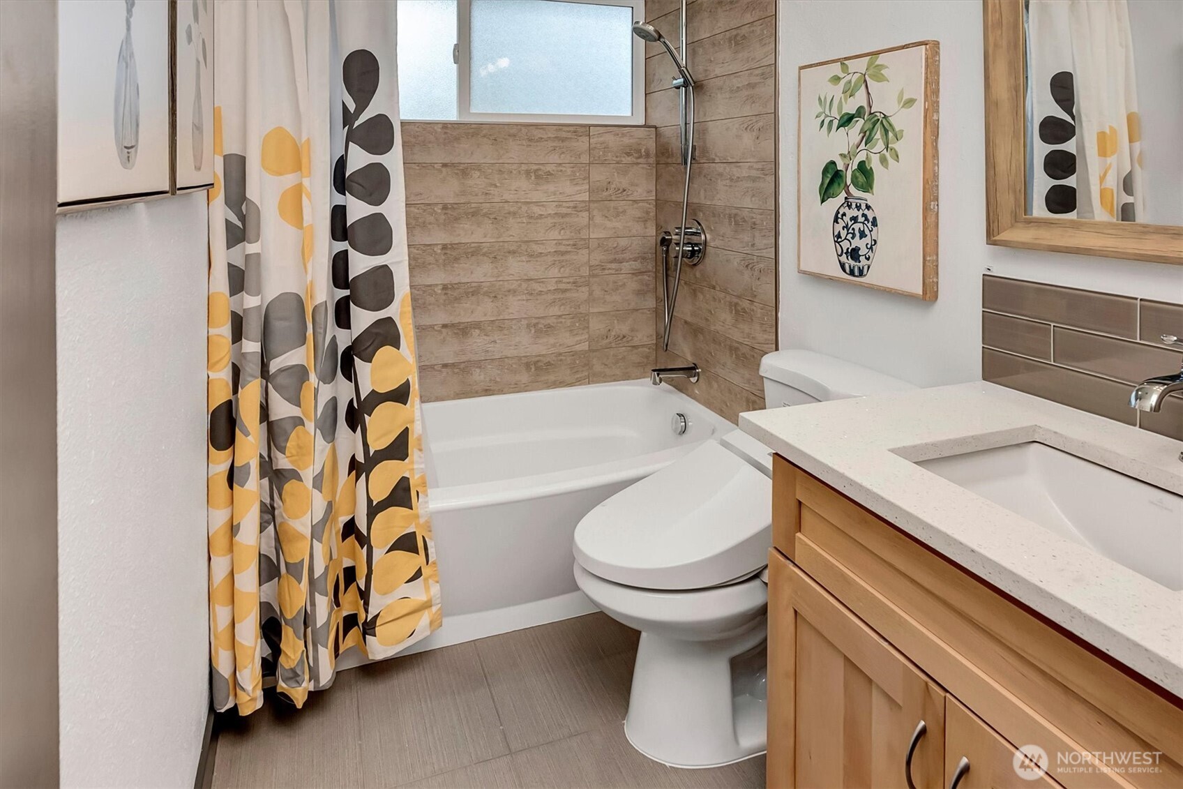 The fully updated bathroom features a deep soaking tub with tiled walls, a subway tile backsplash, a new light fixture, and a TOTO washlet bidet.