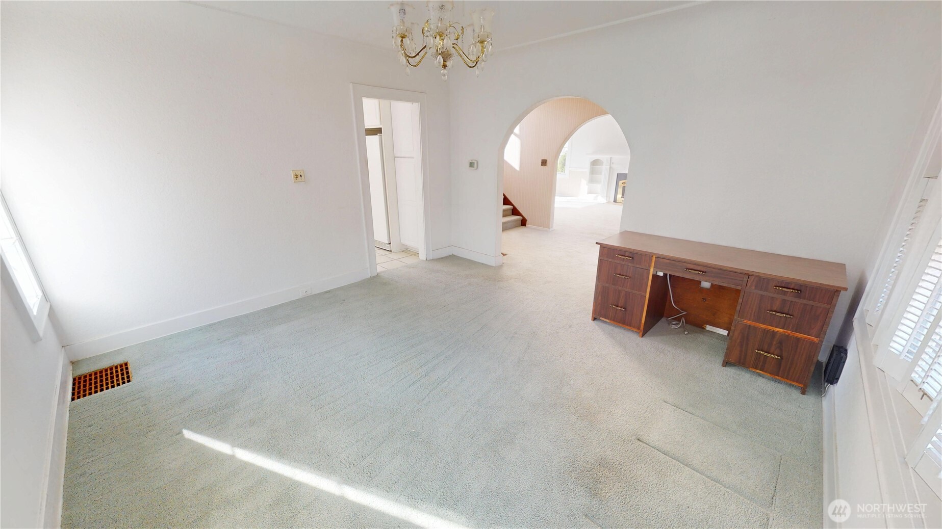 Another view of the dining room.  There are hardwood floors under the carpets- pull up the carpets and refinish the floors- make this home shine again.