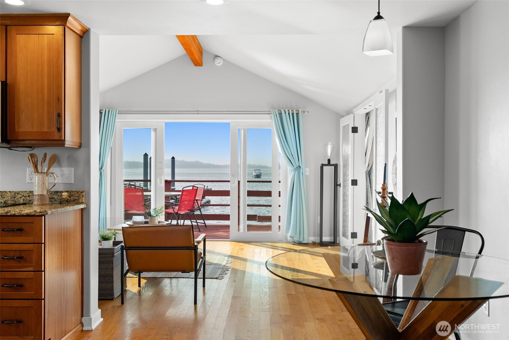 Dining area flowing into open living and deck, ideal for entertaining with views.
