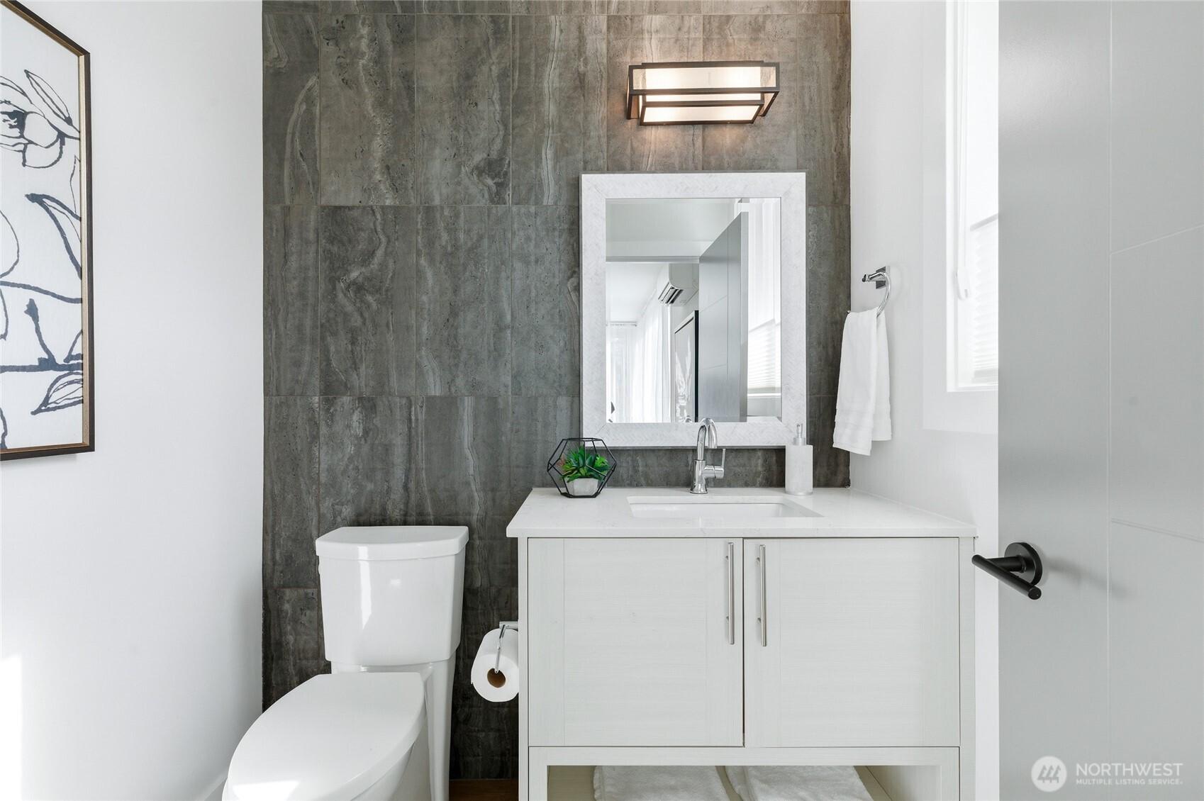 Powder room for guests with impeccable modern design and tile wrapped wall