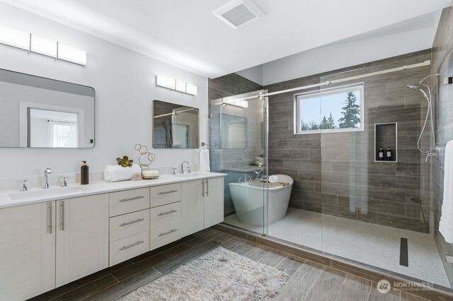 Gorgeous Primary bathroom with soaking tub and heated floors & tile wrapped walls