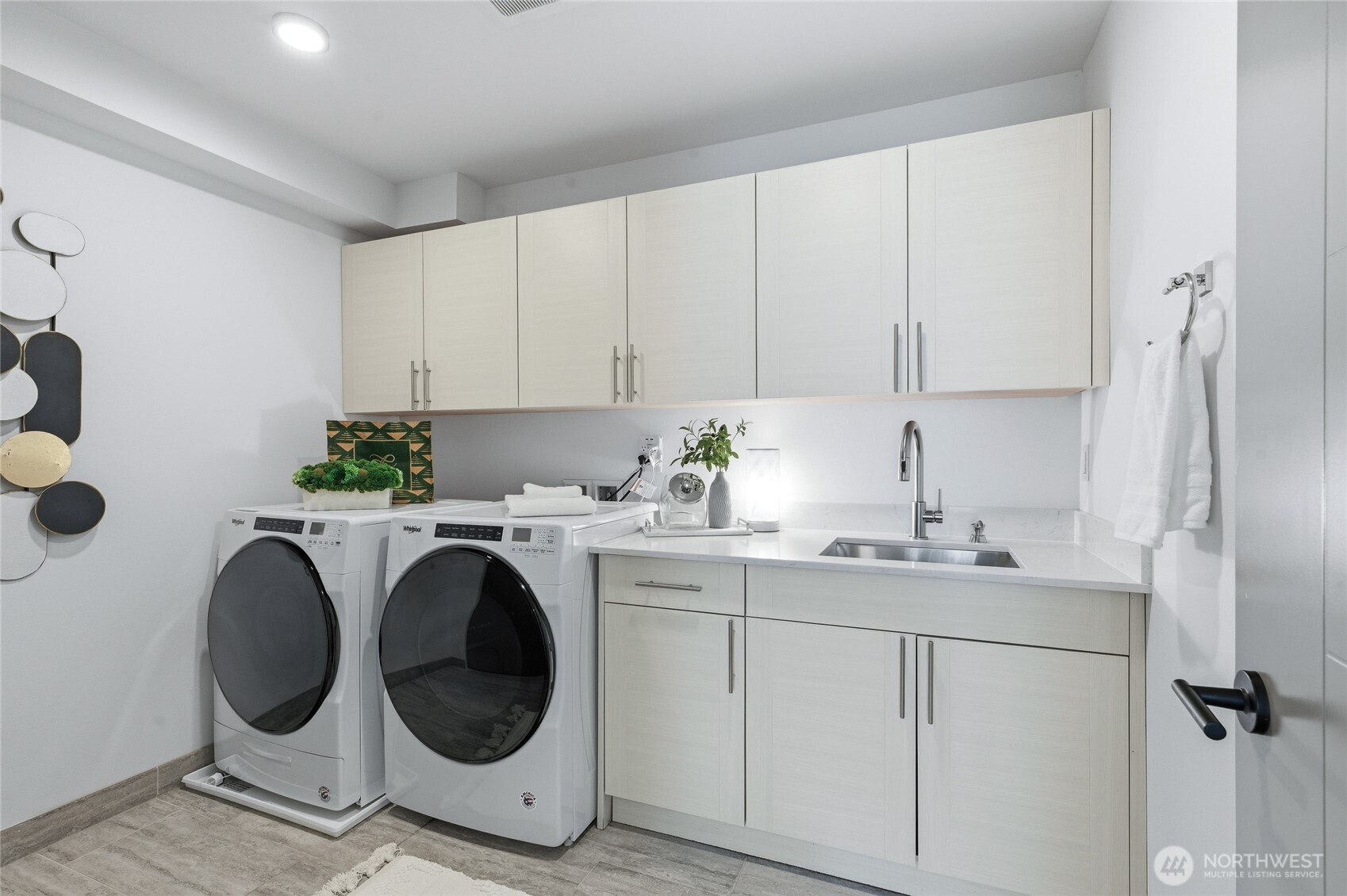 Another bonus - an oversized laundry room with an utility sink, built in cabinetry and additional storage room.
