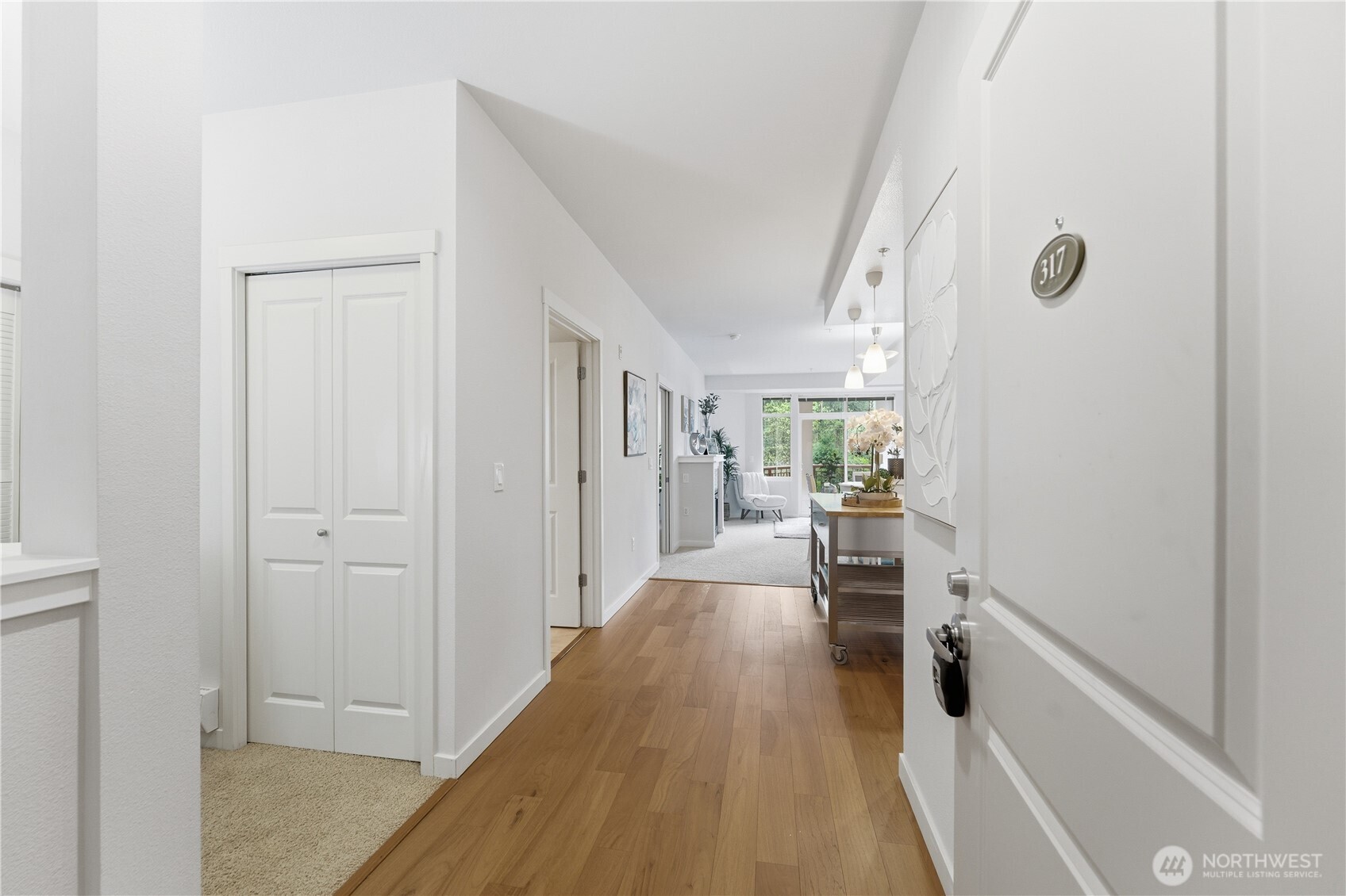 Welcoming entryway with the office/utility room just to the left and a sightline that carries all the way to the lush balcony outlook
