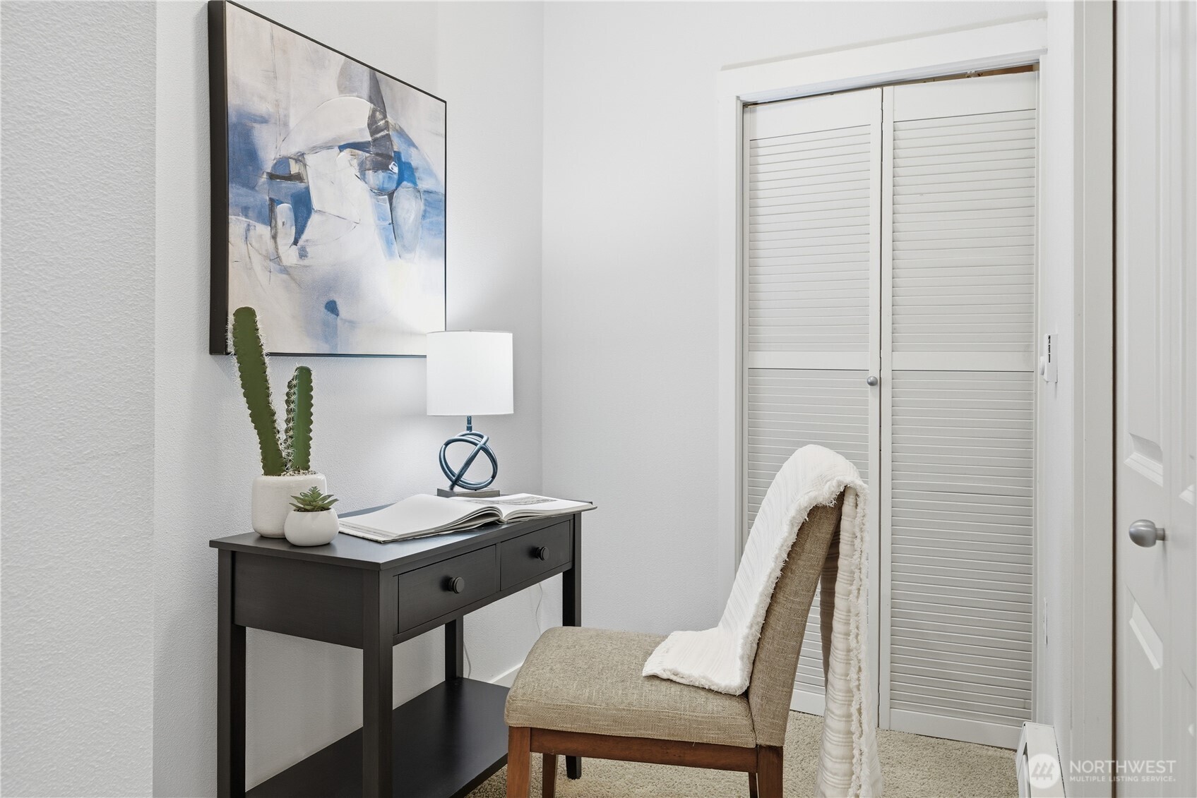 Versatile office or utility room with a full closet concealing the in-unit washer and dryer