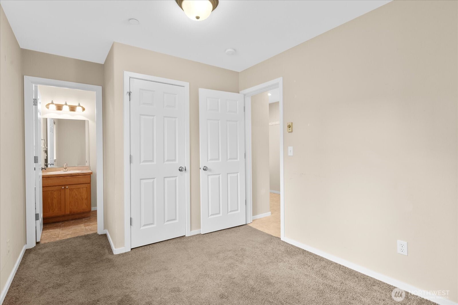 Bedroom with carpeted flooring, and access to a private bathroom.
