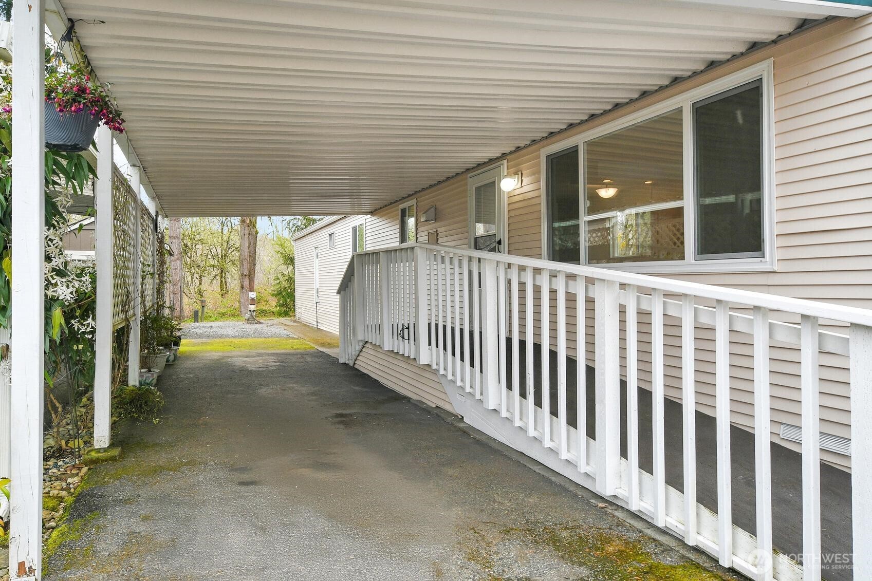 Sturdy and secure carport keeps you dry as you enter the home. Features both a ramp and a set of stairs and has space for two parked cars.