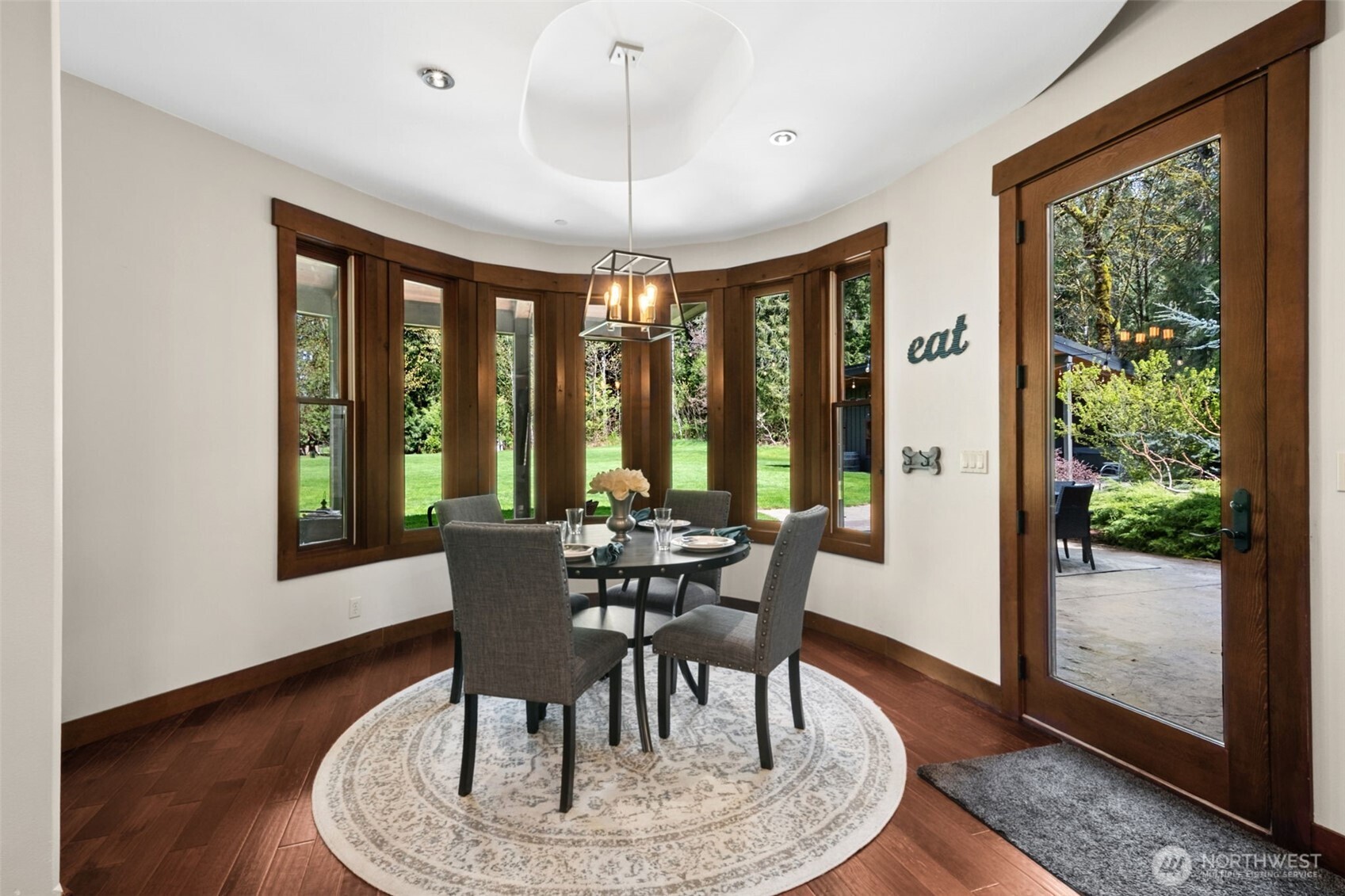 A statement ceiling surrounded by a wall of windows that bring in natural light and serene views of the lush grounds makes this a standout nook! Its subtle curved design creates an intimate dining space, perfectly positioned with direct access to the patio for effortless indoor-outdoor living.