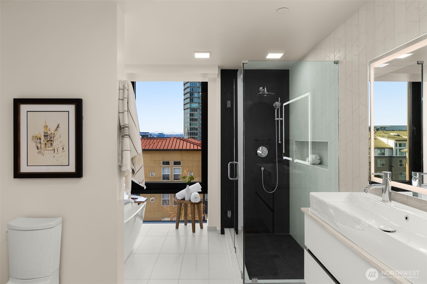 Luxurious Primary ensuite with heated floors, walk-in ceramic shower and a soaking tub with views.