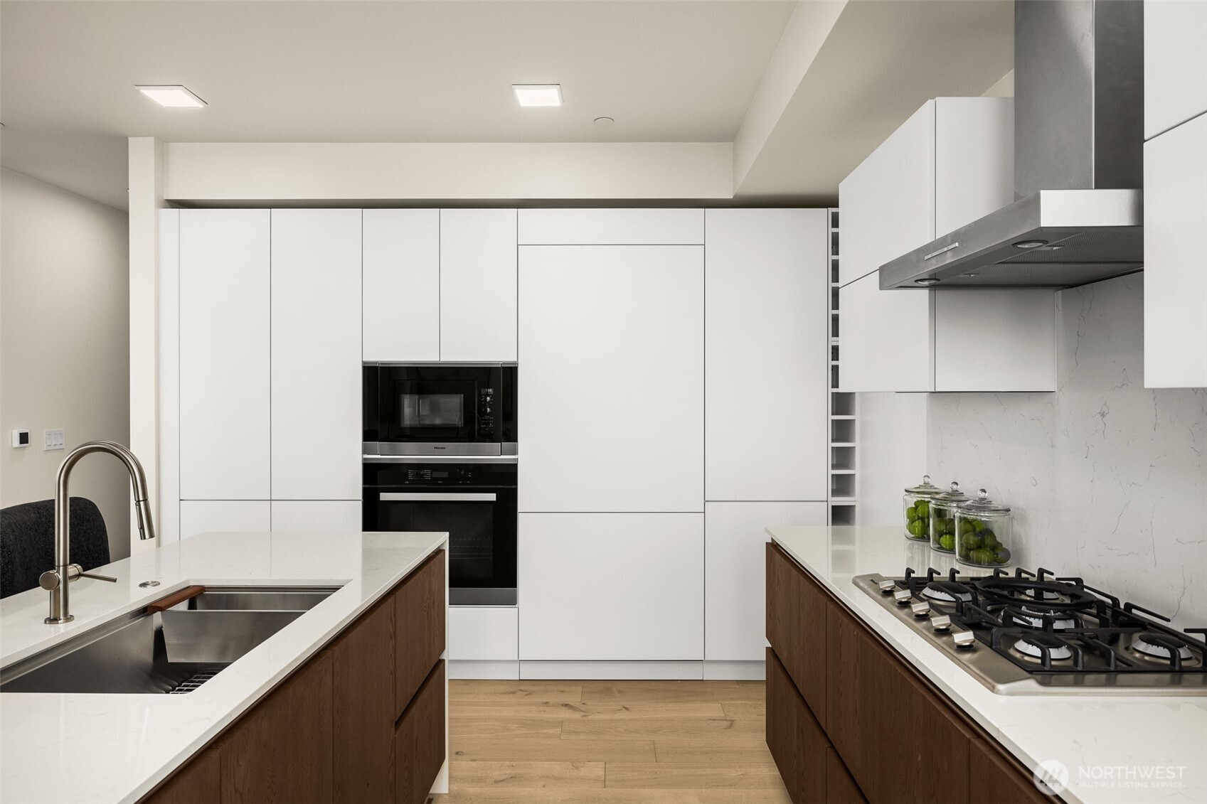 Ultra custom kitchen with Smart Glass Cabinetry, Miele custom paneled appliances, gas range and a waterfall island.