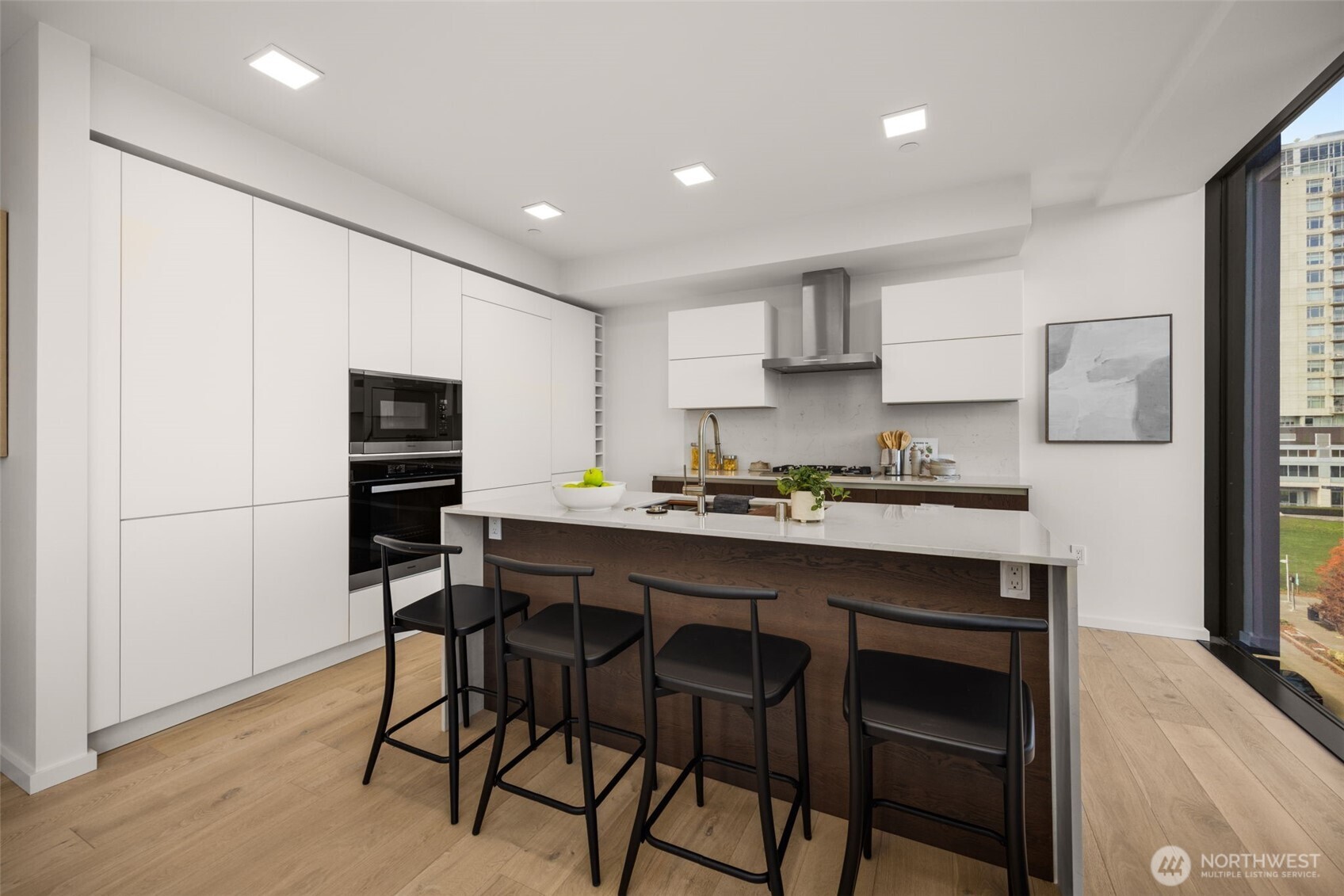 Custom kitchen with Smart Glass Cabinetry, Miele custom paneled appliances, gas range and a waterfall island.