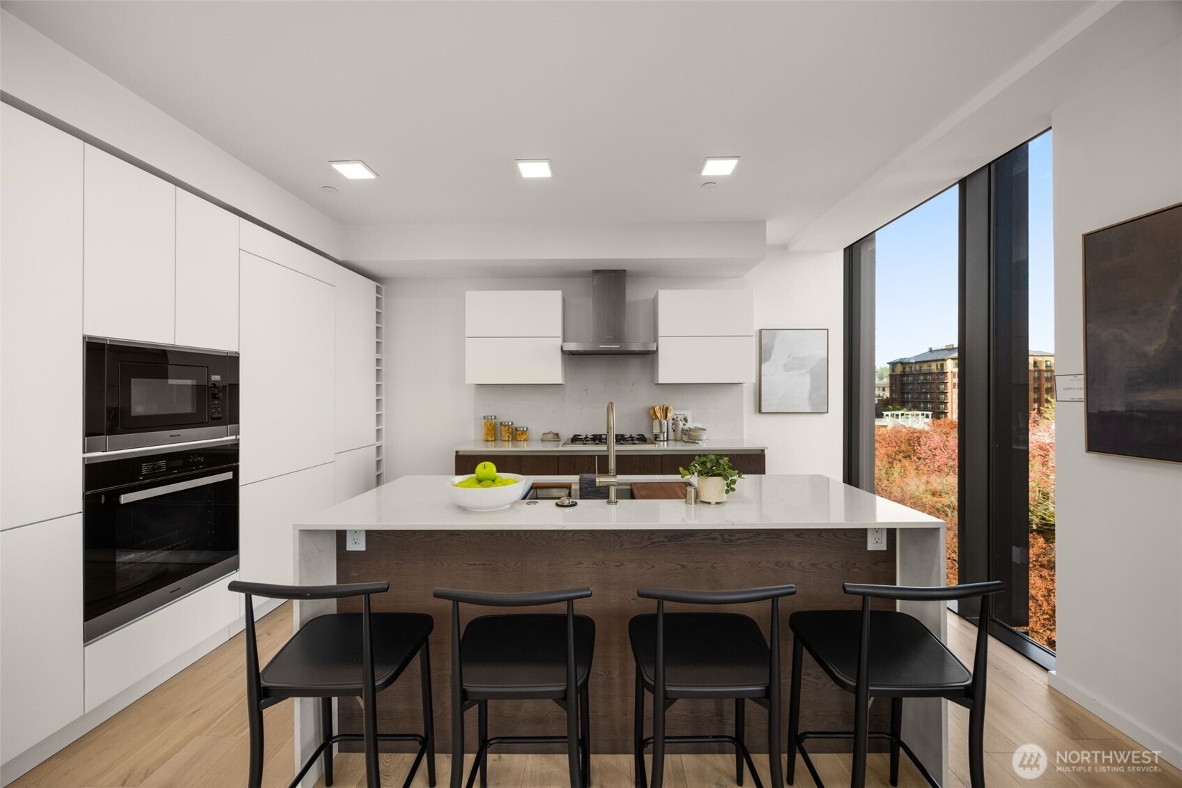 Custom kitchen with Smart Glass Cabinetry, Miele appliances, gas range and a waterfall island.