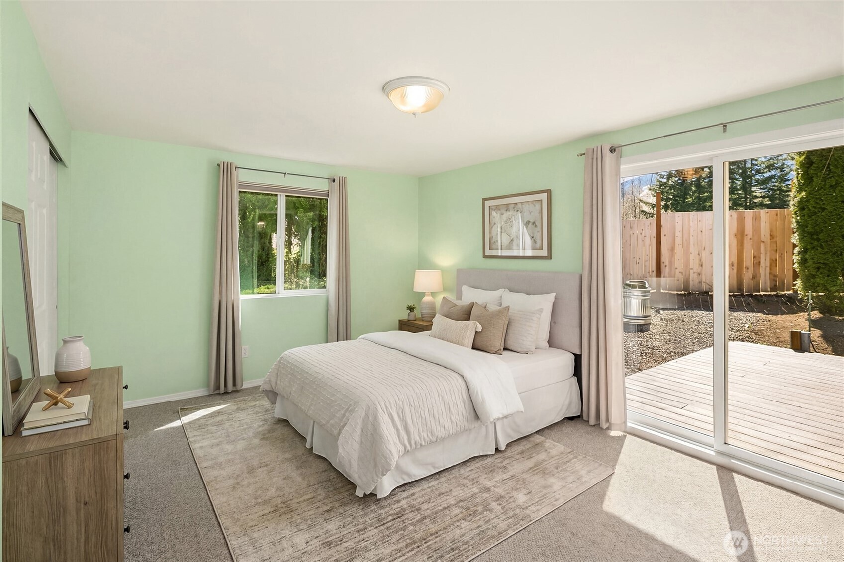 Primary bedroom out to the trex deck and raised garden planters -- Virtually staged