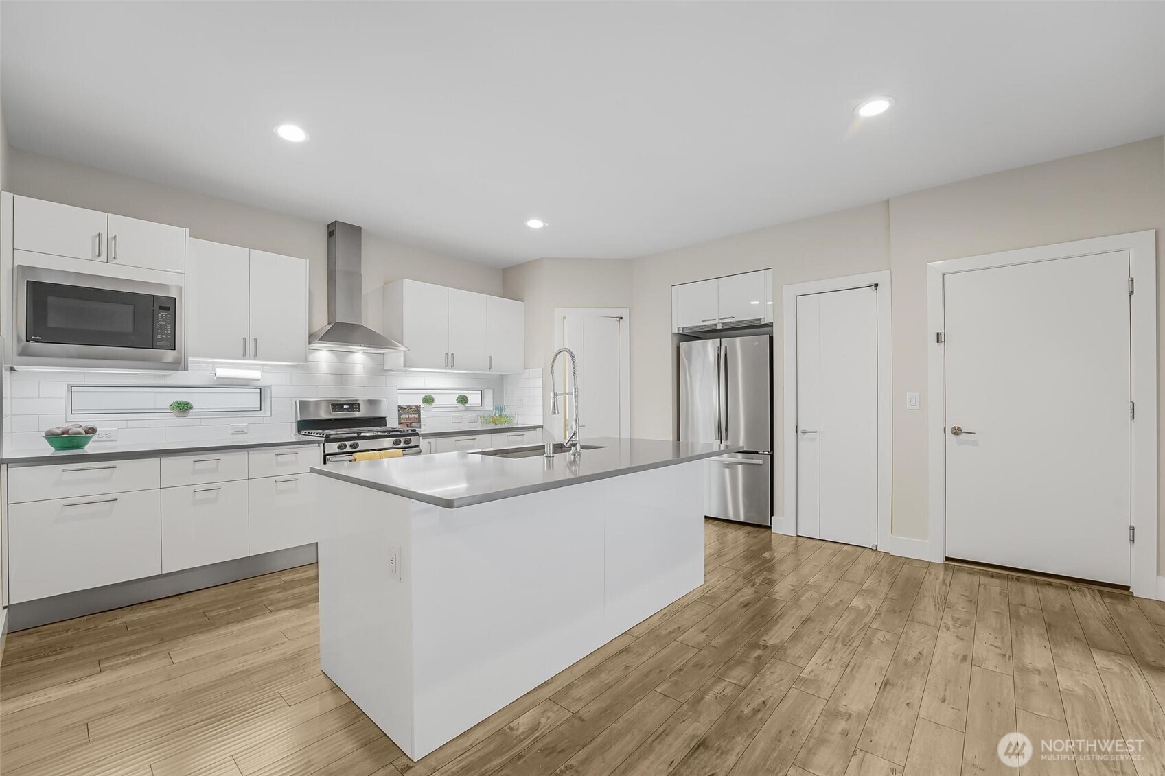 White piano finish cabinets w/Blum pull-down shelves and quartz countertops