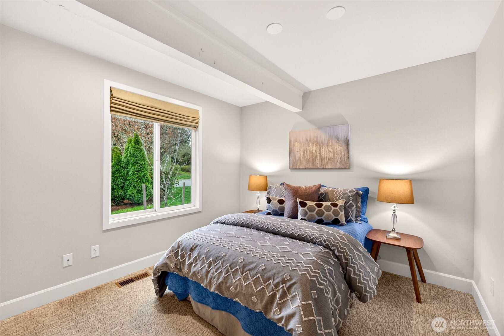 This bedroom offers a cozy and private feel with a garden view window, plush carpet, and a compact footprint perfectly suited for a guest room, home office, or secondary sleeping space.