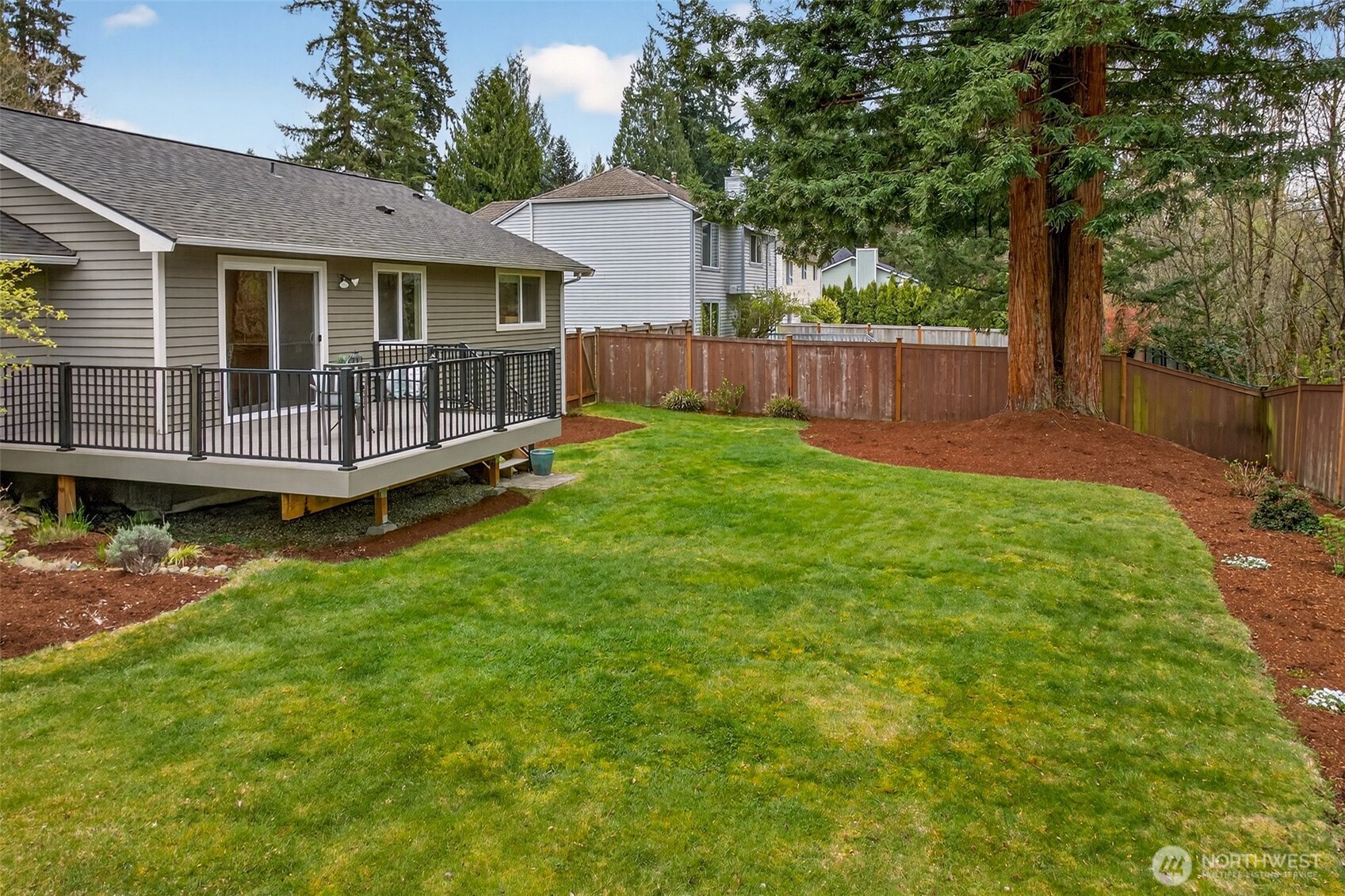 A fully fenced, level backyard with fresh landscaping and a mature greenbelt tree line along the rear fence creates a private outdoor environment that's rare to find in established Redmond neighborhoods. No HOA means you use this space exactly as you choose.