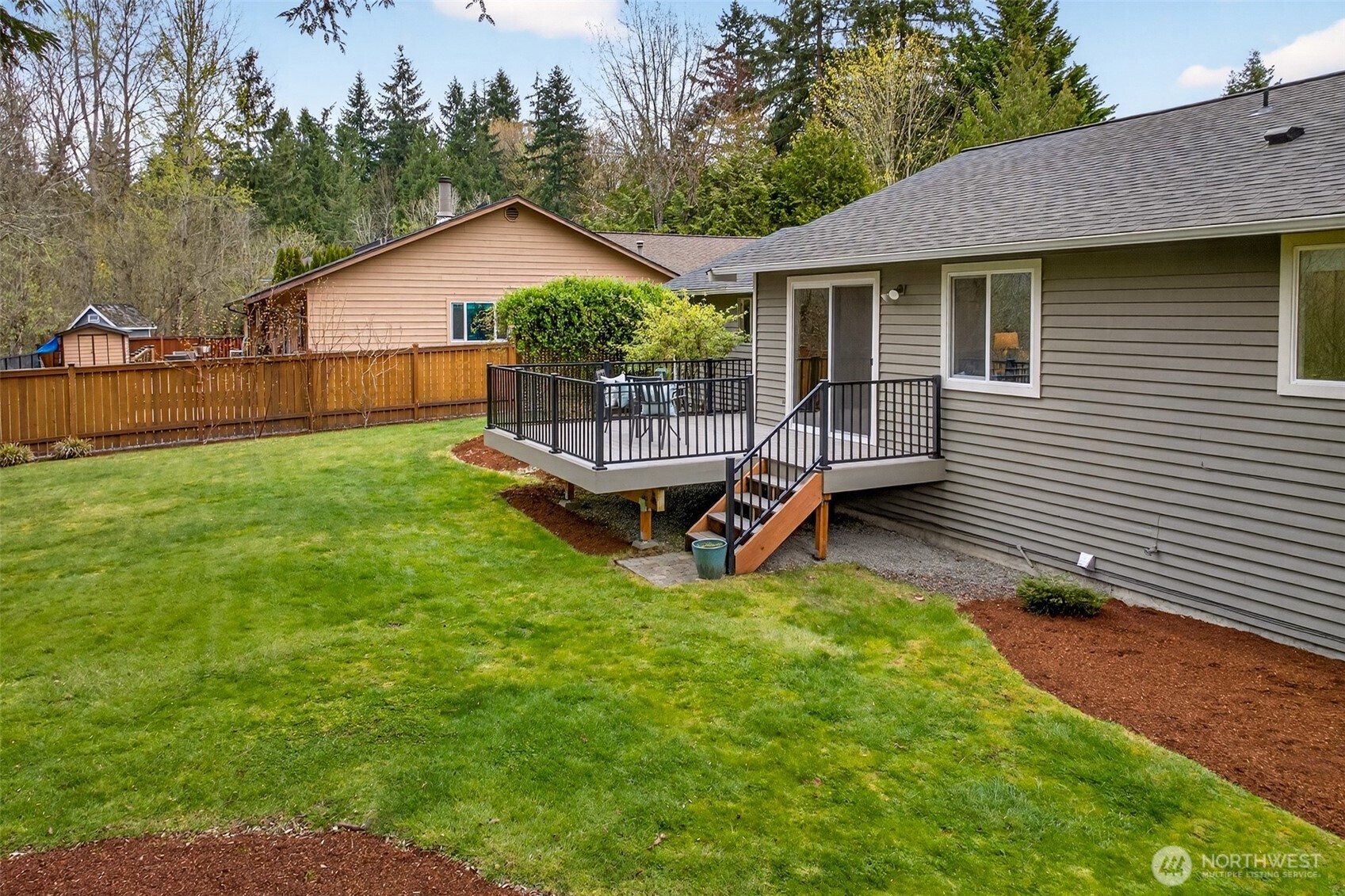 The spacious, level lawn extends generously to the side of the property, offering room for outdoor activities, gardening, or future landscaping additions — all within the privacy of a fully fenced yard. The 8,062 SF lot gives this home outdoor proportions that significantly outpace typical Eastside offerings at this price range.