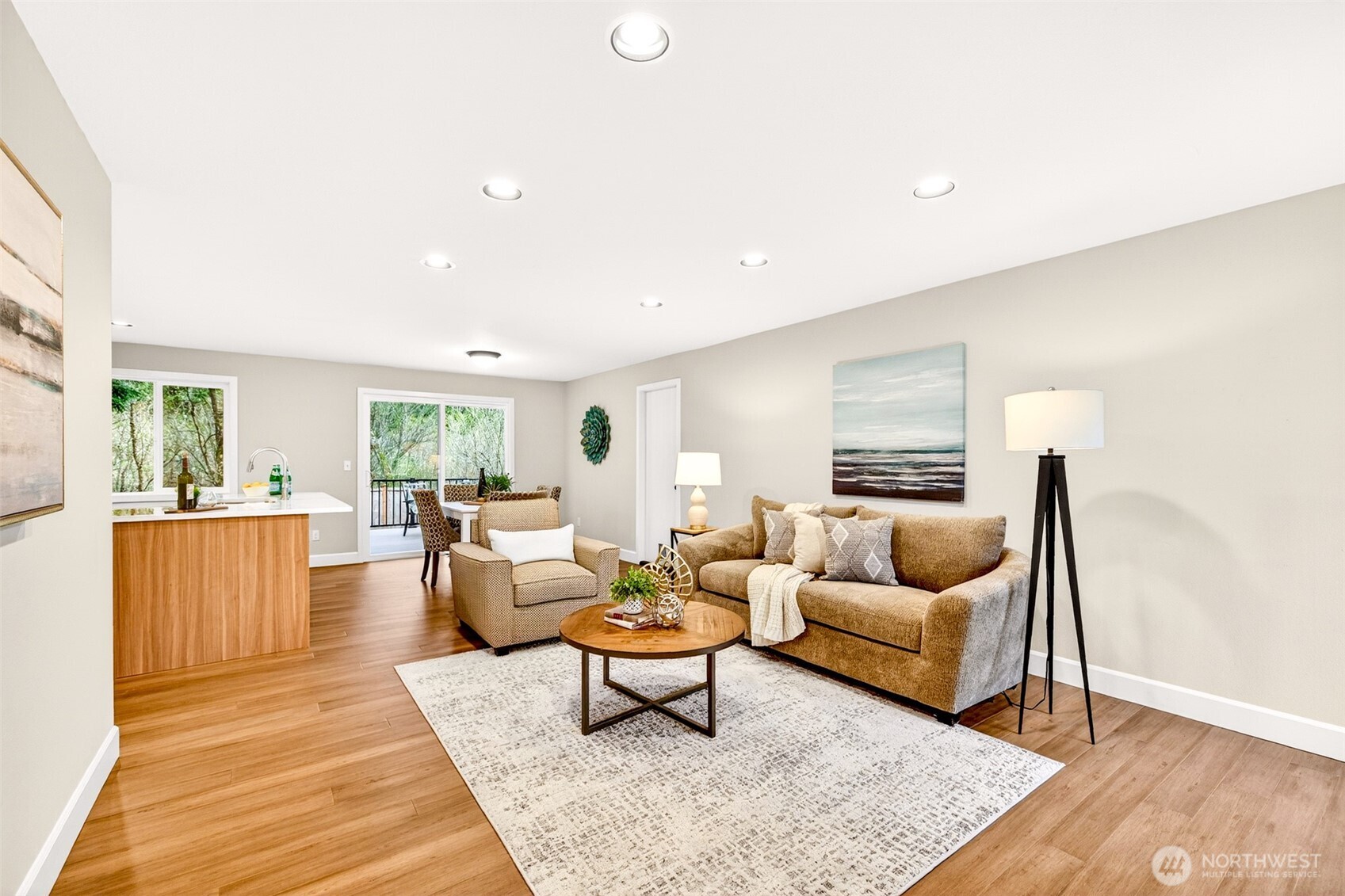 The open-concept main level flows seamlessly from the living area through to the kitchen and dining space, making everyday living and entertaining equally effortless. Sliding glass doors draw the eye to the rear greenbelt, flooding the space with natural light and connecting you to the private outdoor setting.