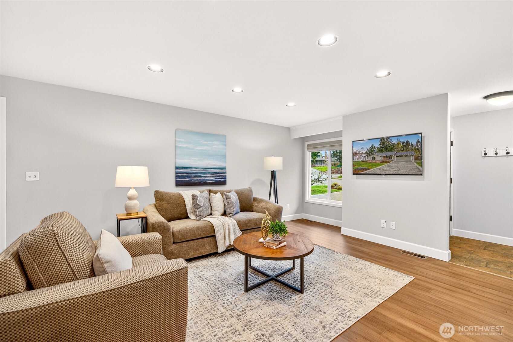 Recessed lighting and rich hardwood floors — updated in 2019 — give this living space a polished, move-in-ready feel that requires nothing from a new owner. The layout is flexible and open, with easy sightlines to both the front yard and the rear greenbelt beyond.
