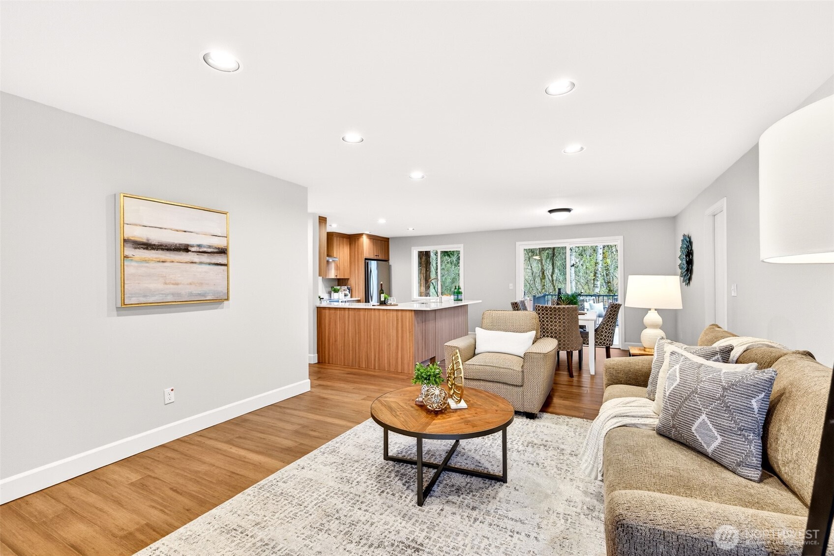 The great room's open sightline to the fully updated 2026 kitchen makes this the true heart of the home, ideal for hosting or simply enjoying daily life with everything within reach. Custom walnut-tone cabinetry, quartz countertops, and a stainless appliance suite are visible from every angle of this connected living space.